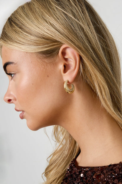 Profile view showing gold tone rhinestone hoop earring on woman with blonde hair