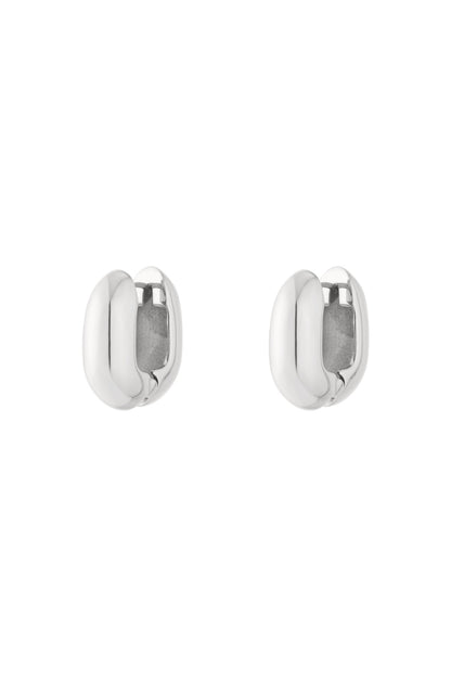 Pair of chunky oval hoop earrings in polished silver finish isolated on white background