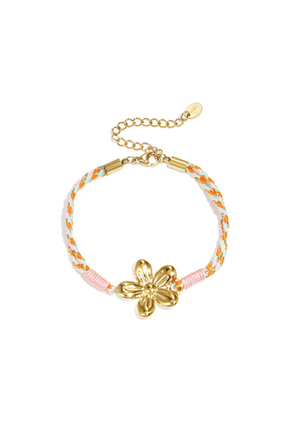 Close-up of pink braided rope bracelet with gold sunflower charm on white background