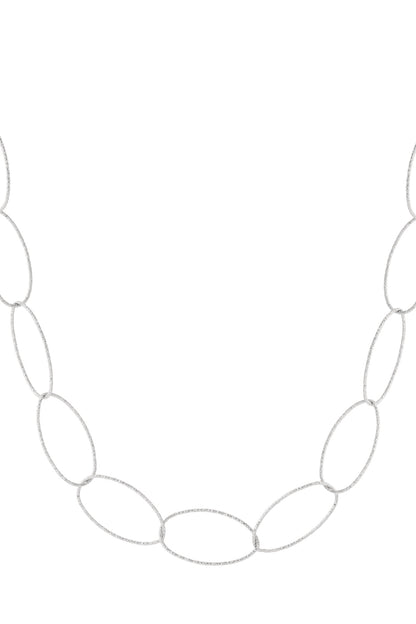 Close-up of textured silver-tone chunky oval link necklace on white background