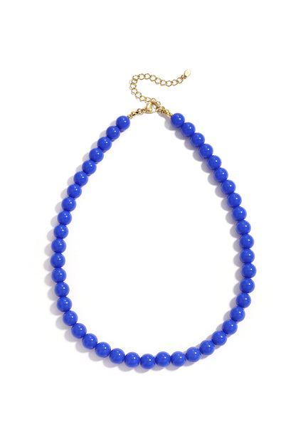 A vibrant blue resin beaded necklace with a gold-tone chain clasp on a white background.