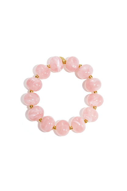Light pink marbled beaded stretch bracelet with gold spacer beads on white background
