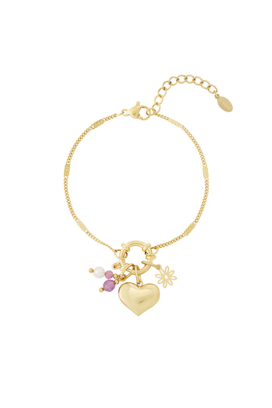 Gold charm bracelet with heart pendant and attached pink, white, and gold charms including a flower for a playful personalized look