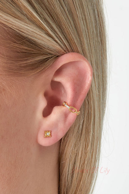 Model wearing gold chain link ear cuff on upper ear with small star stud earring in lower lobe