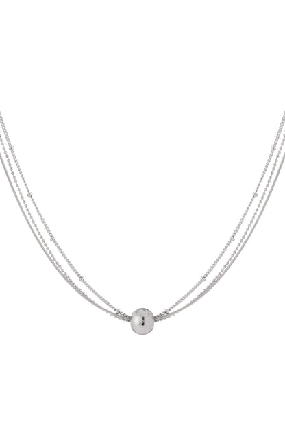 Silver layered necklace with tiny beads and a smooth spherical pendant displayed on a white background