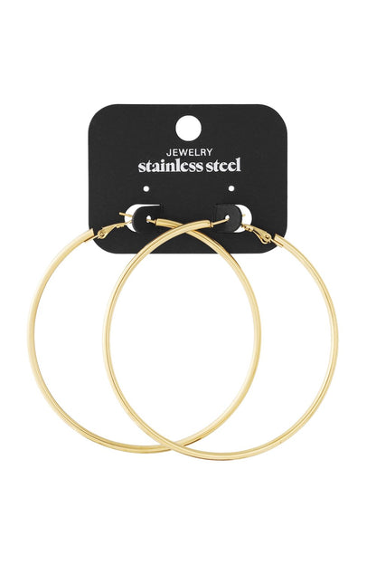 Cloud Drift Loops: Large, minimalist gold-tone stainless steel hoop earrings on a black display card.