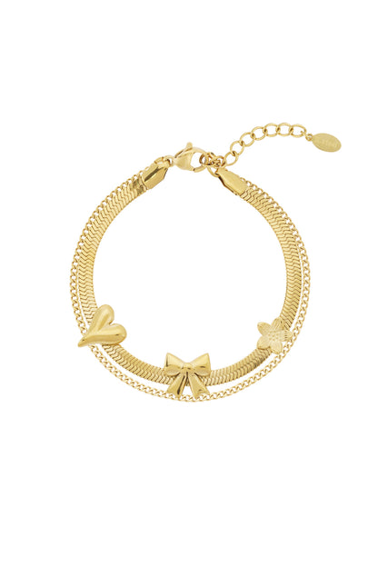Gold stainless steel charm bracelet with bow, heart, and flower charms on white background
