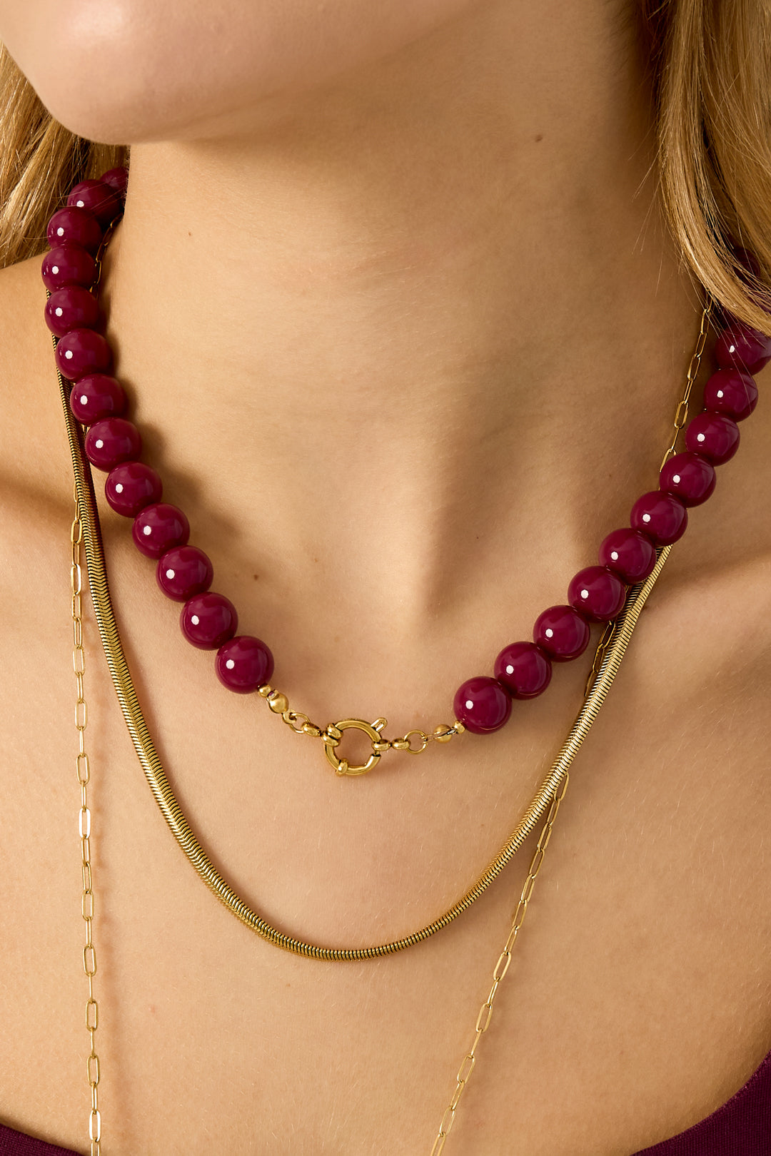 Single strand necklace with glossy lavender resin beads and gold spring ring clasp on white background