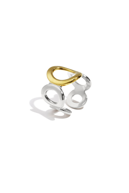 Gold and silver two-tone open circle ring with oval shapes on white background showing design details