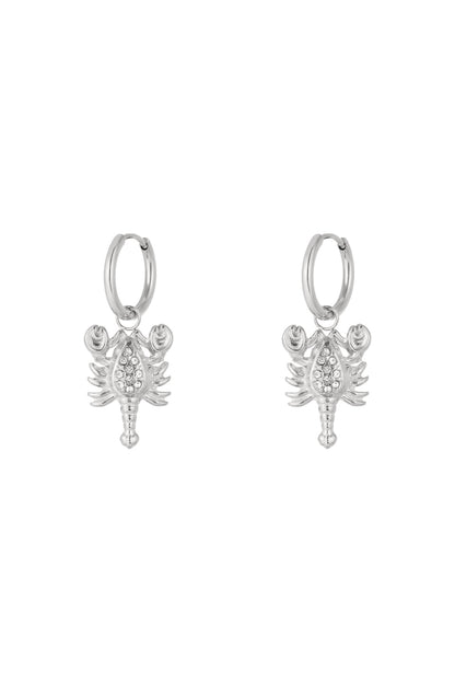 Pair of silver Scorpio charm hoop earrings with rhinestone details on a white background