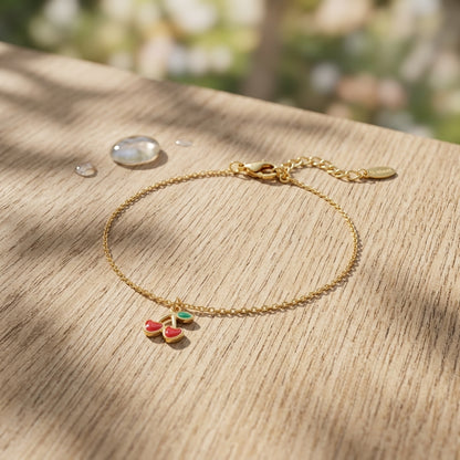 Close-up of the cherry love bracelet made of stainless steel with lobster clasp resting on textured wooden surface, highlighting its polished finish and delicate links.