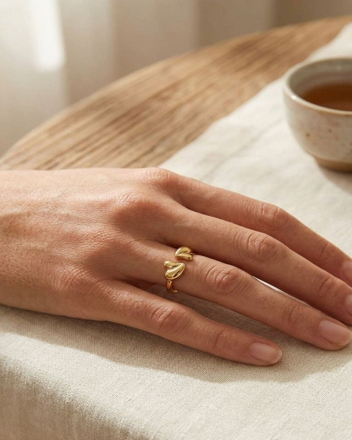 Close-up of the small Bubbly Heart Stacking ring on a slender finger, showcasing intricate heart motifs and stainless steel shine.