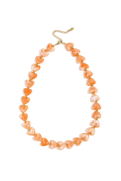 Dark amber brown heart bead necklace with gold spacers on white background