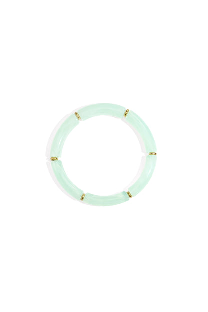 Mint green resin tube bracelet with gold-tone ring spacers displayed on white background