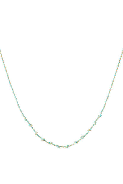 Greenish turquoise knotted cotton necklace with gold accents laid flat on white background