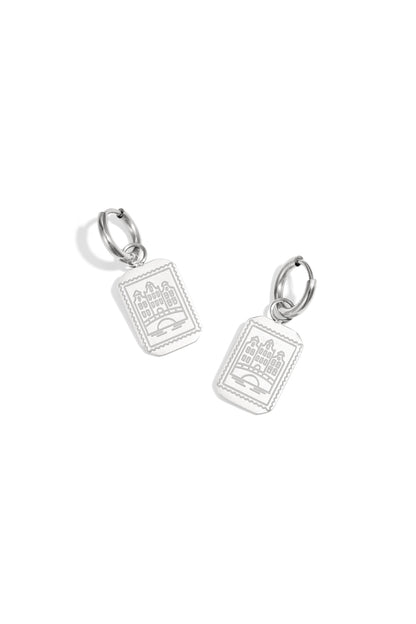 Pair of silver drop earrings with rectangular Amsterdam canal house pendants on a white background.
