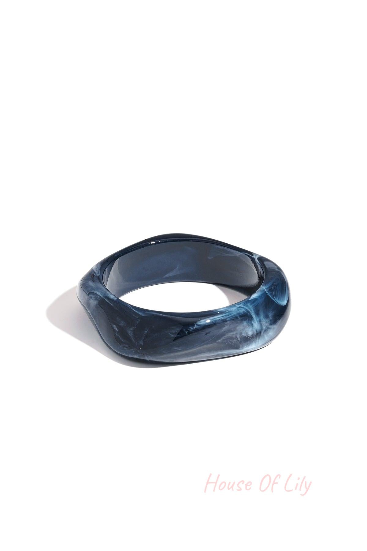Single navy blue marbled acrylic wavy square bangle on a white background