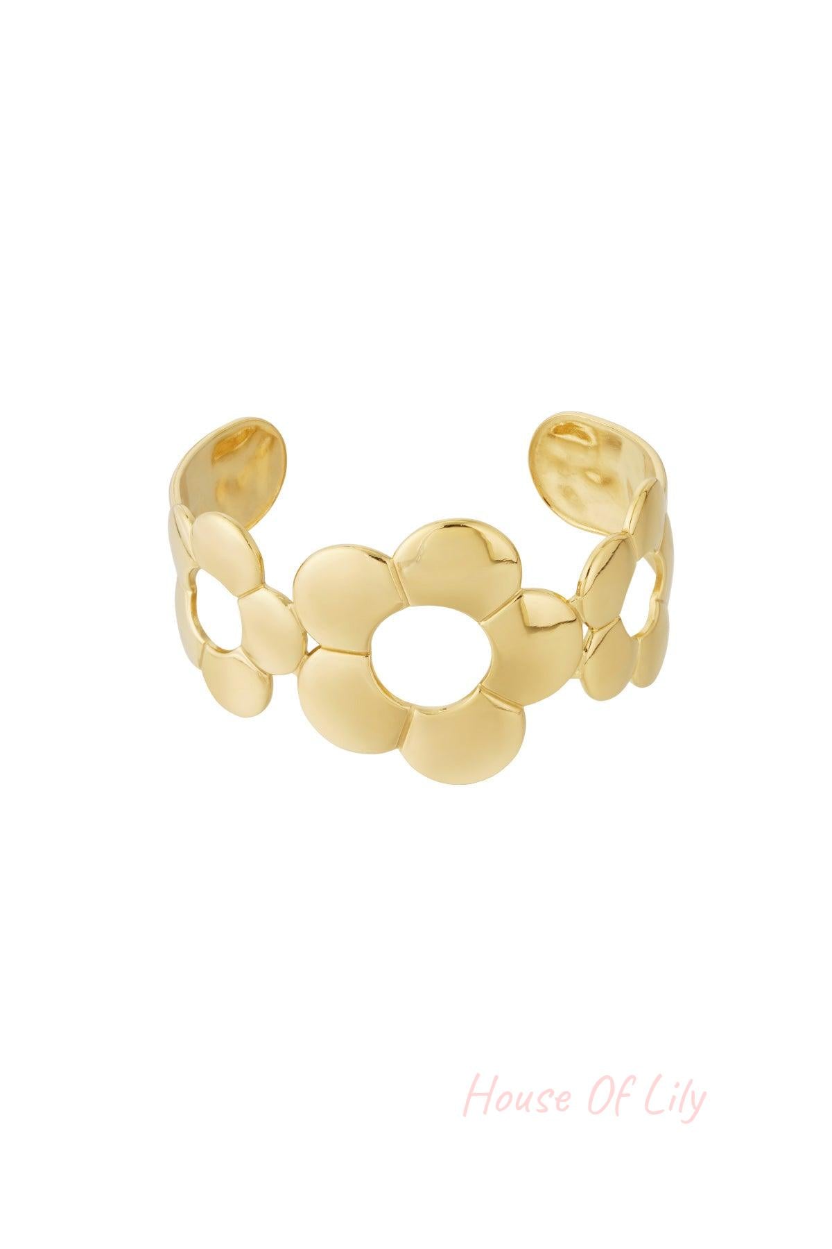 Gold-toned open cuff bracelet featuring three large stylized flower shapes with open centers, designed for women.