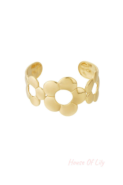 Gold-toned open cuff bracelet featuring three large stylized flower shapes with open centers, designed for women.