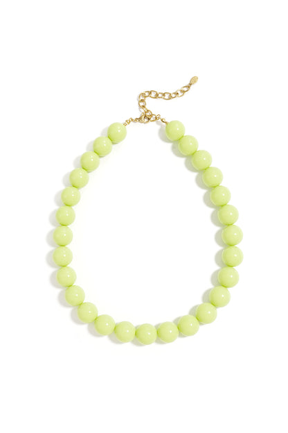 Light pink chunky resin beaded necklace with gold chain clasp photographed on white background