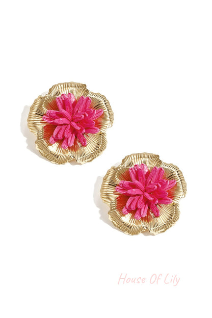 Side profile of woman wearing orange raffia flower earrings, highlighting the lightweight and dimensional design