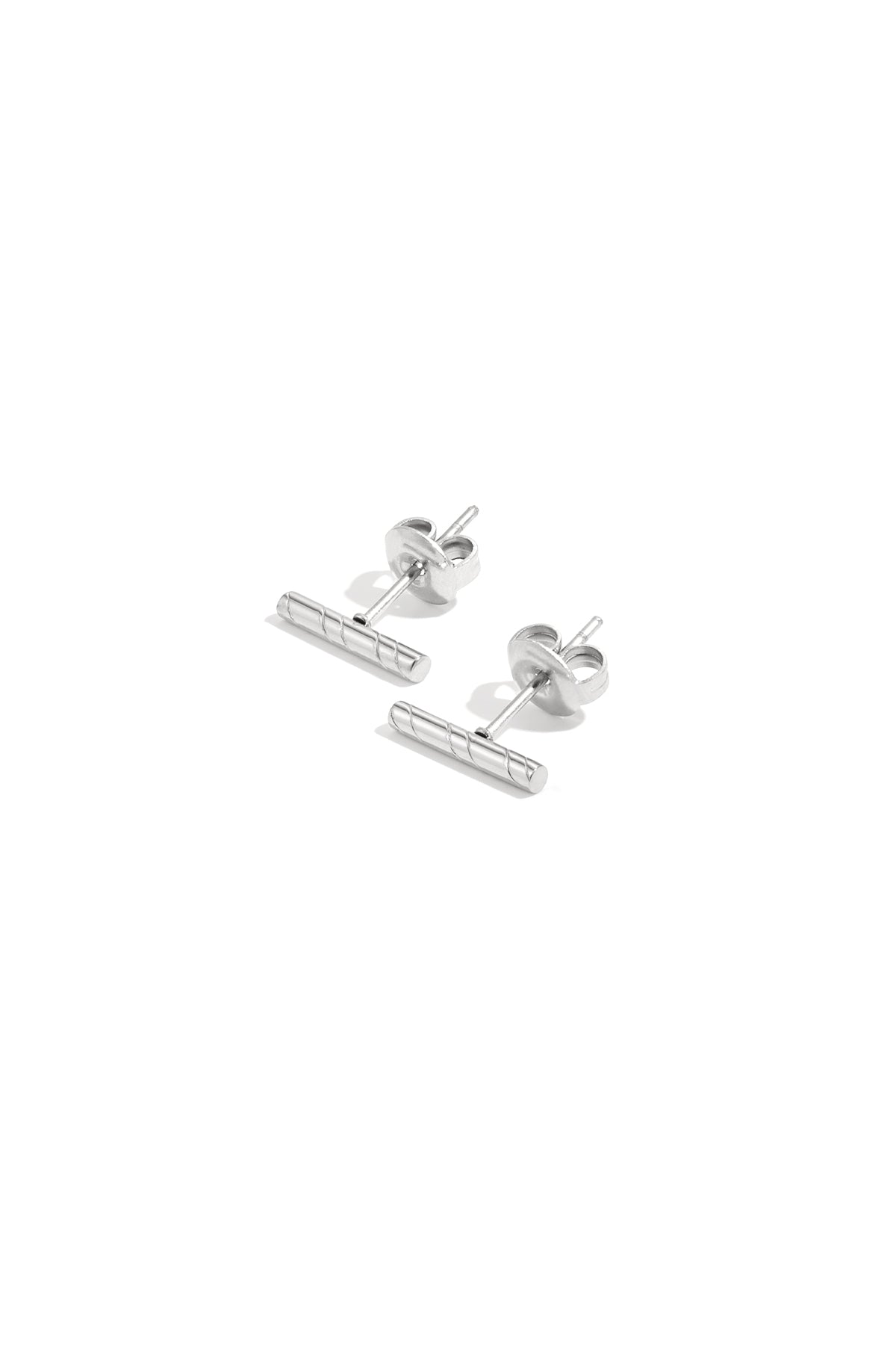 Silver minimalist bar stud earrings with diagonal line pattern on white background