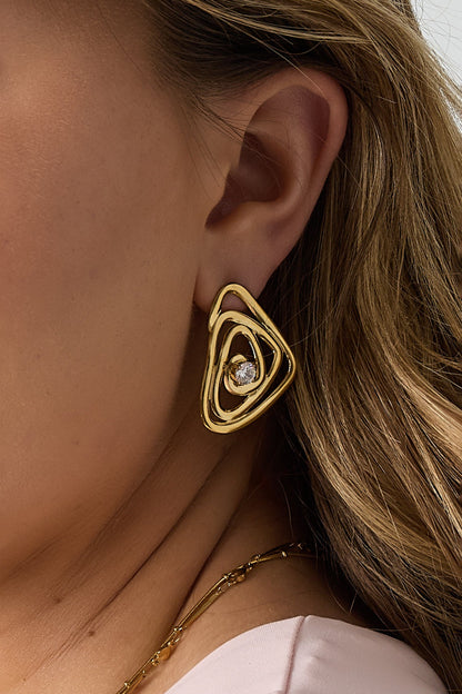 Detailed side profile of the wire spiral gold earring with rhinestone worn by a woman