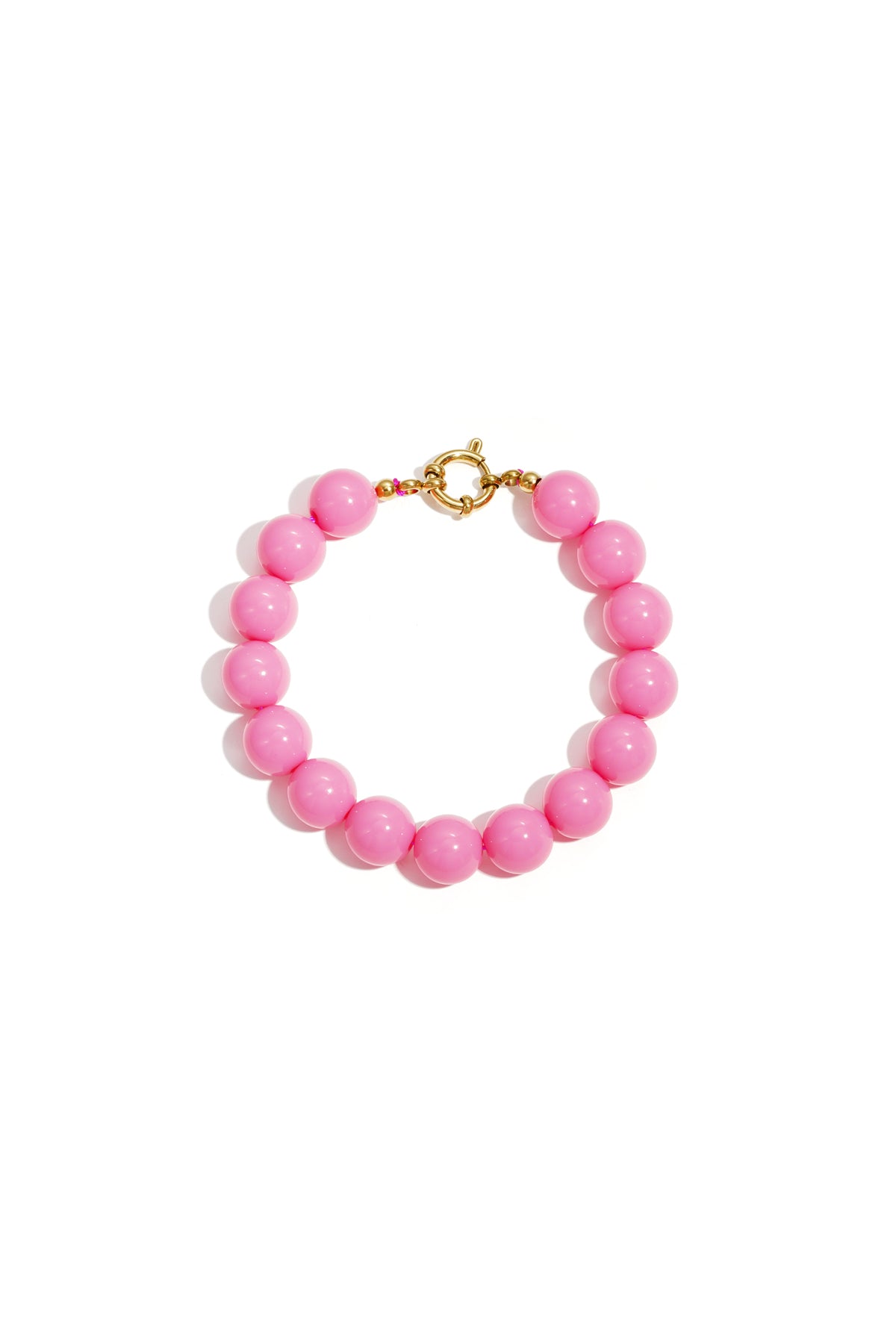 Pink resin bead bracelet with gold toggle clasp on white background