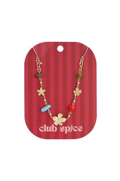 Gold-tone chain necklace featuring floral charms and colorful beaded accents on a red Club Spice display card.