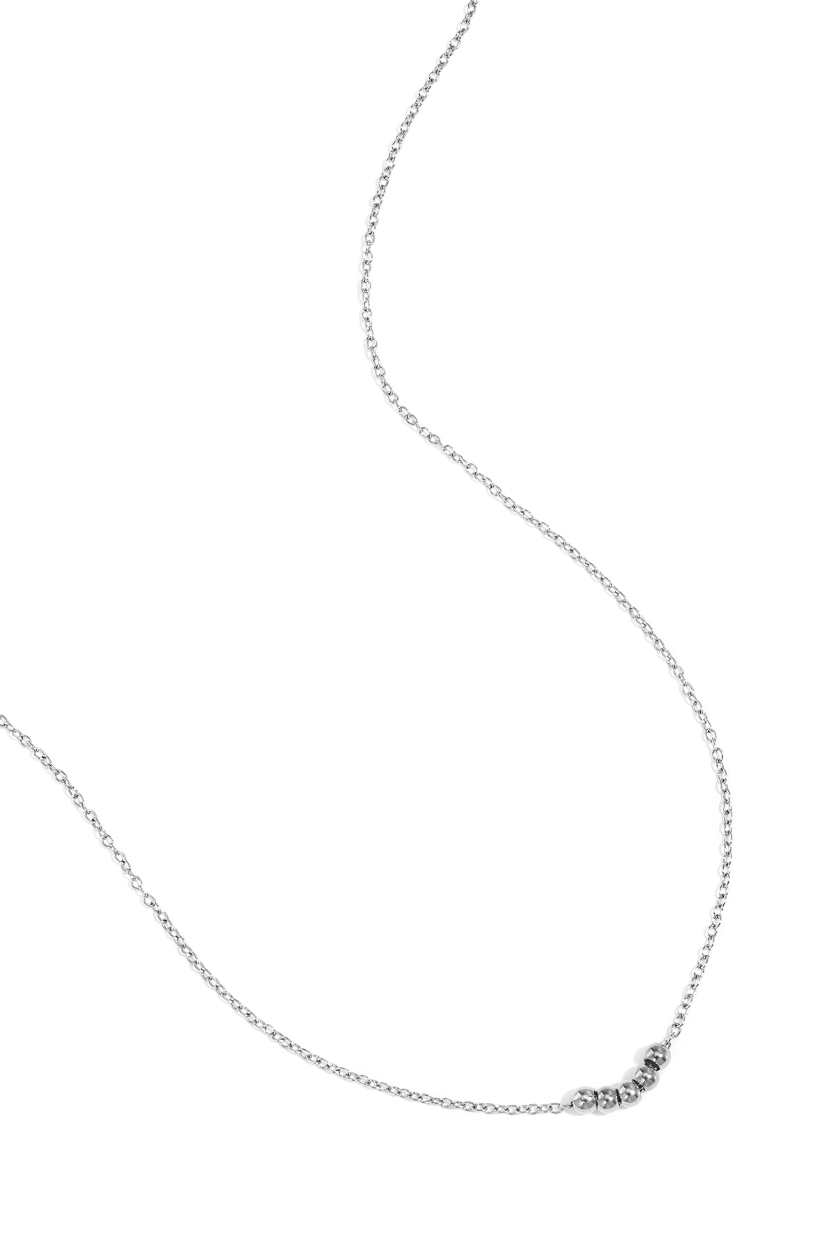 Silver ball chain necklace laid flat on white background showing chain and five beads
