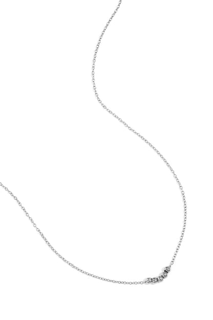 Silver ball chain necklace laid flat on white background showing chain and five beads