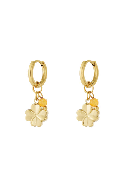 Gold hoop earrings with small four-leaf clover charms and yellow faceted bead accents shown on white background
