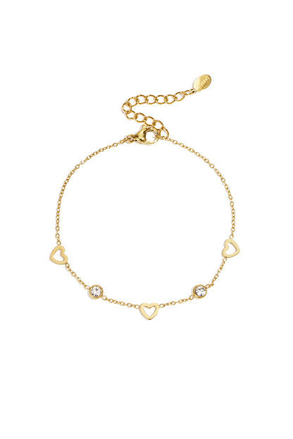 Gold delicate chain bracelet with open heart charms and small clear rhinestones on a white background