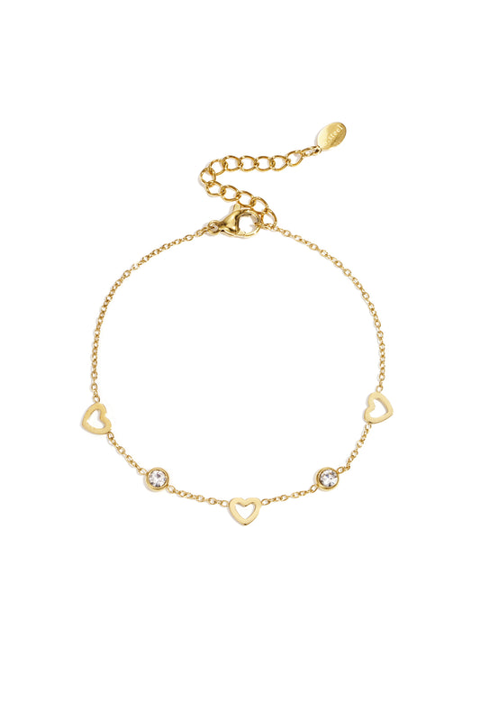 Gold delicate chain bracelet with open heart charms and small clear rhinestones on a white background