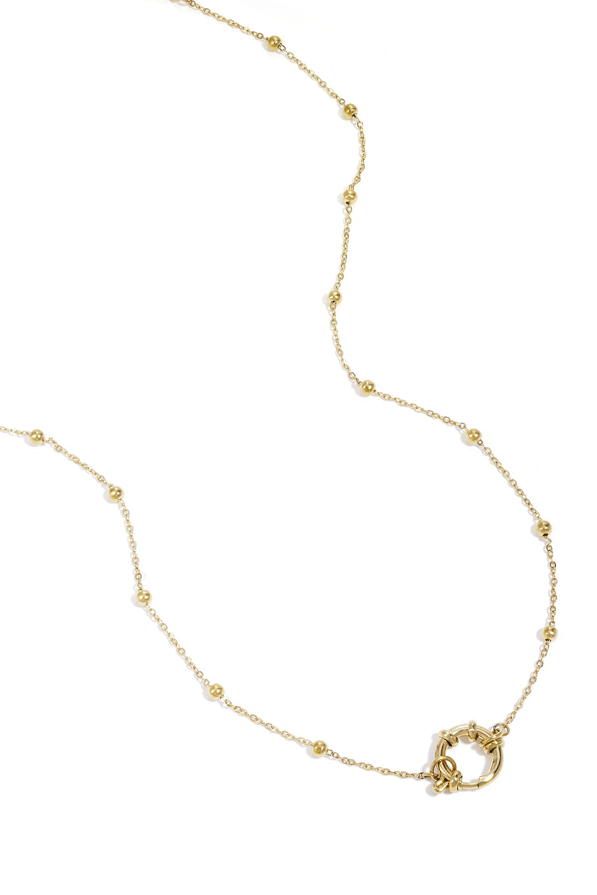 Close-up of delicate gold chain necklace with small round beads and circular clasp against white background
