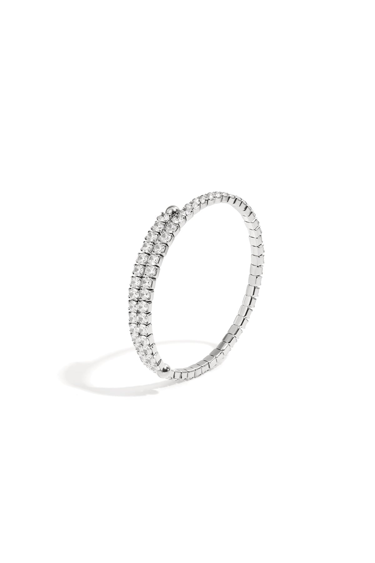 Silver-tone cuff bracelet featuring double rows of clear sparkling crystals on a flexible band against white background