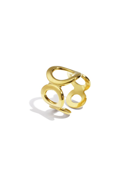 Close-up of a shiny gold open circle ring with oval cutouts on a white background