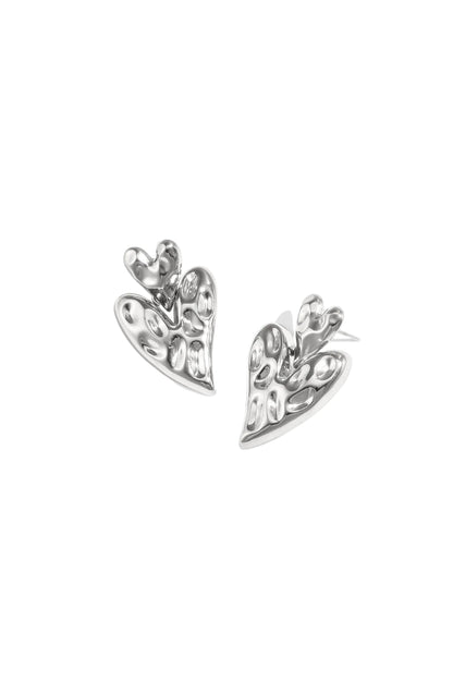 Pair of polished silver chunky heart-shaped drop earrings with hammered texture on white background