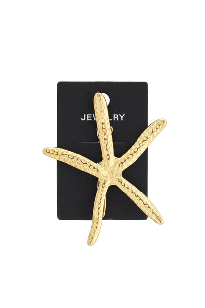 Gold-tone starfish brooch featuring a textured, pitted surface, mounted on a black display card.