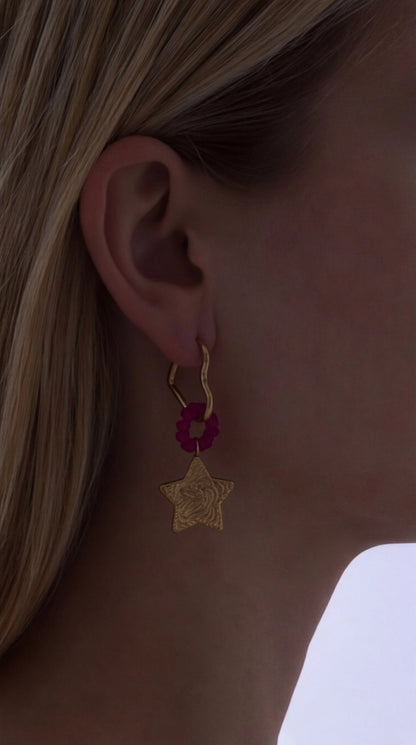 Shooting Star Drops: Gold star pendant with a fuchsia beaded accent hanging from a gold heart-shaped hoop earring.