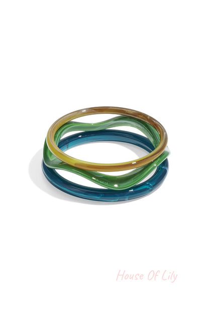 Two acrylic bangles in amber tortoise and red shades stacked on white background