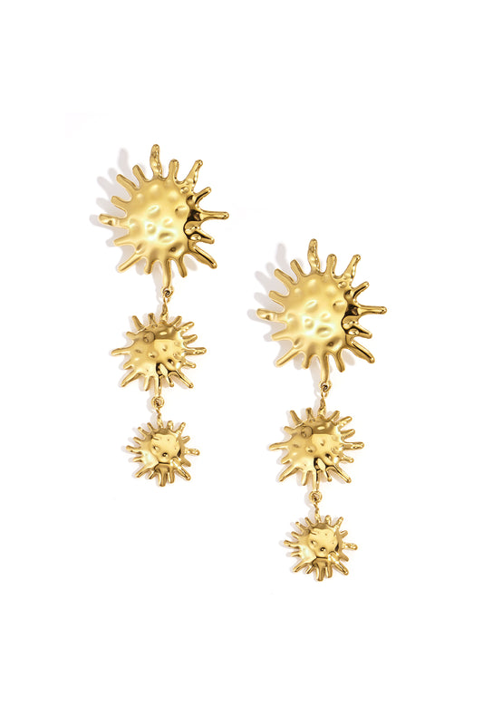 Pair of gold sunburst dangle earrings with three linked sun shapes on white background