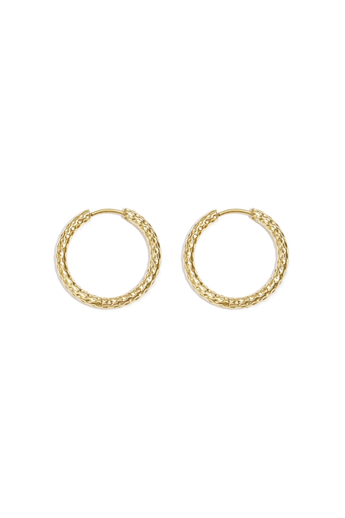 Close-up image of a pair of textured gold hoop earrings laid flat on white background