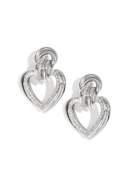 Silver heart-shaped drop earrings with rhinestones on a white background