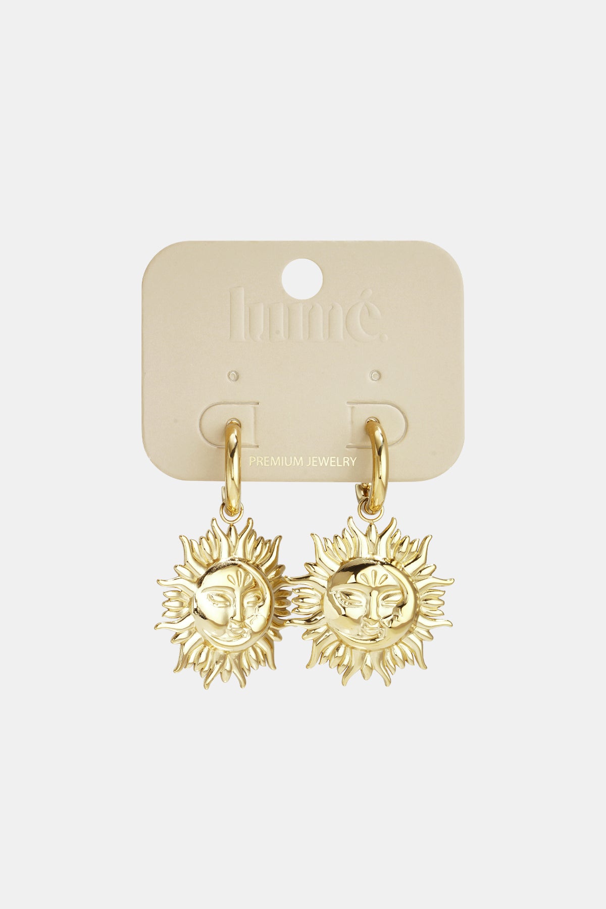 Gold sun face drop earrings displayed on branded jewelry card background