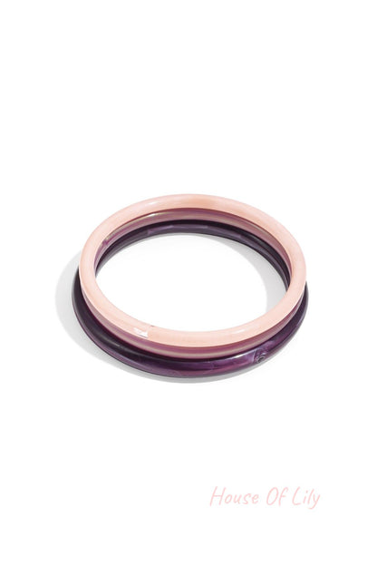 Purple and pink marbled resin bangle set with glossy surface isolated on white