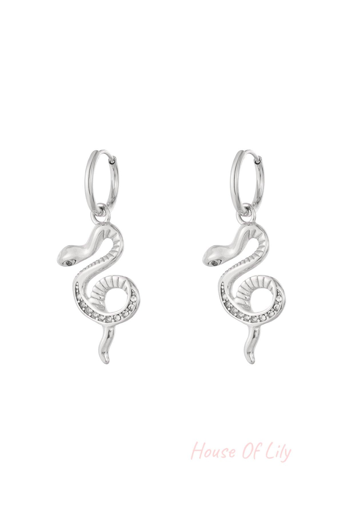 Pair of silver snake charm hoop earrings with rhinestone accents on a white background.