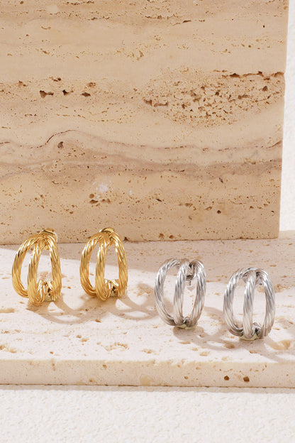 Gilt Twist Hoops: two pairs of small, double-layered twisted metal hoop earrings in gold and silver on a stone base.