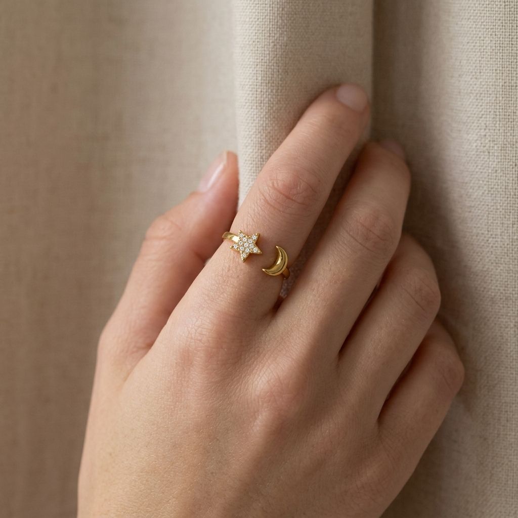Model holding the celestial ring against a beige fabric background, showcasing its dainty size and adjustable band in a natural setting.