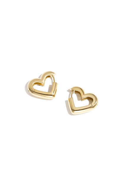 Close-up of gold heart-shaped hoop earrings isolated on white background